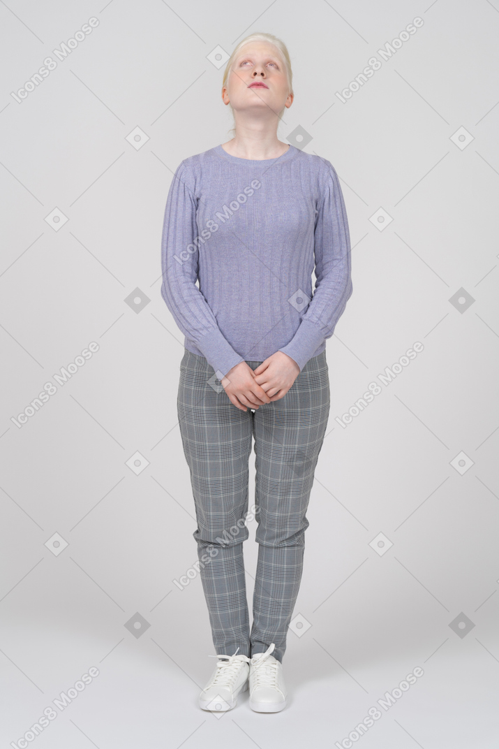 Vista frontal de una mujer rubia con ropa informal mirando hacia arriba