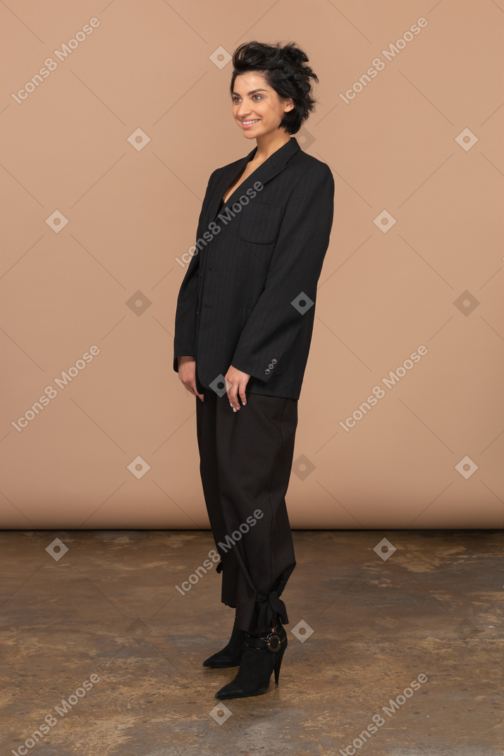 Vista di tre quarti della donna di affari sorridente che porta vestito nero