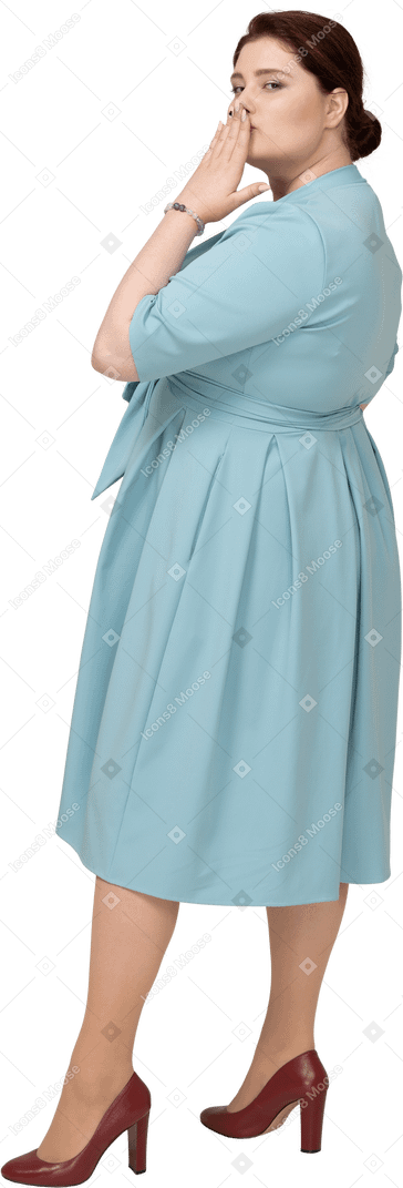 Side view of a woman in blue dress blowing a kiss