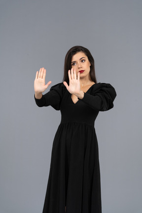 Vista di tre quarti di una giovane donna che rifiuta in un abito nero