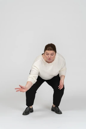 Front view of a plump woman in casual clothes squatting