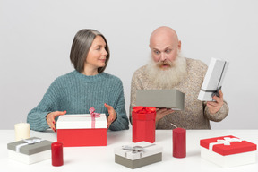 Couple de personnes âgées élégant déballant les cadeaux de noël