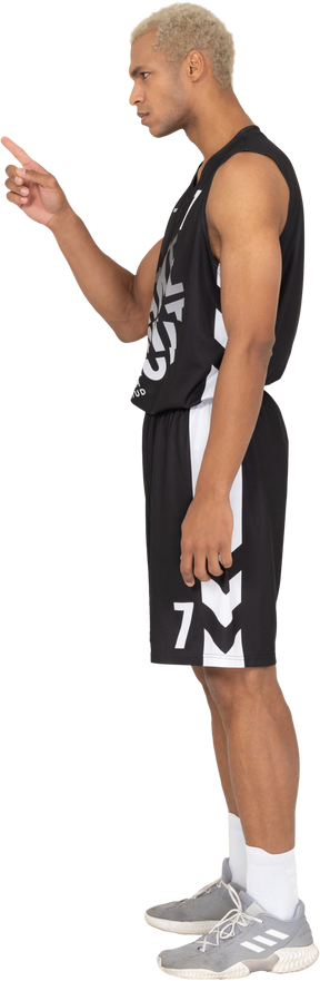 Vista lateral de un joven jugador de baloncesto masculino dedo acusador