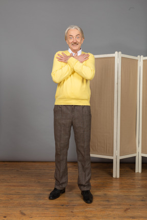 Front view of an excited old man near the screen crossing hands