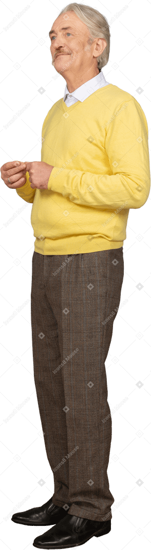 Vista de três quartos de um homem velho em um pulôver amarelo juntando as mãos e olhando para o lado
