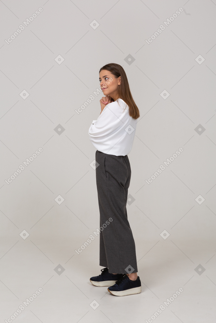 Vista laterale di una giovane donna in abiti da ufficio che si tiene per mano insieme