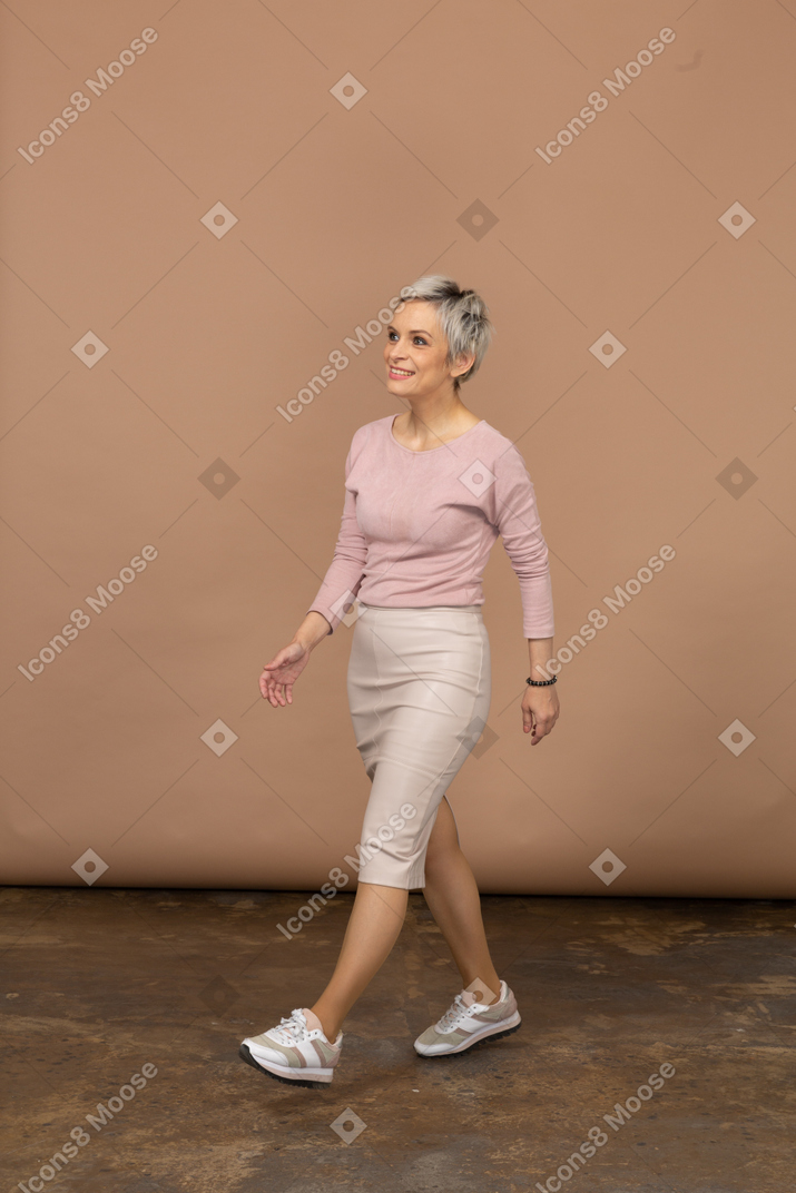 Vista laterale di una donna in abiti casual che cammina