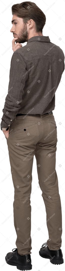 Vista posteriore di tre quarti di un giovane premuroso in abiti da ufficio toccando il mento