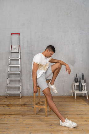 Side view of man in casual clothes sitting