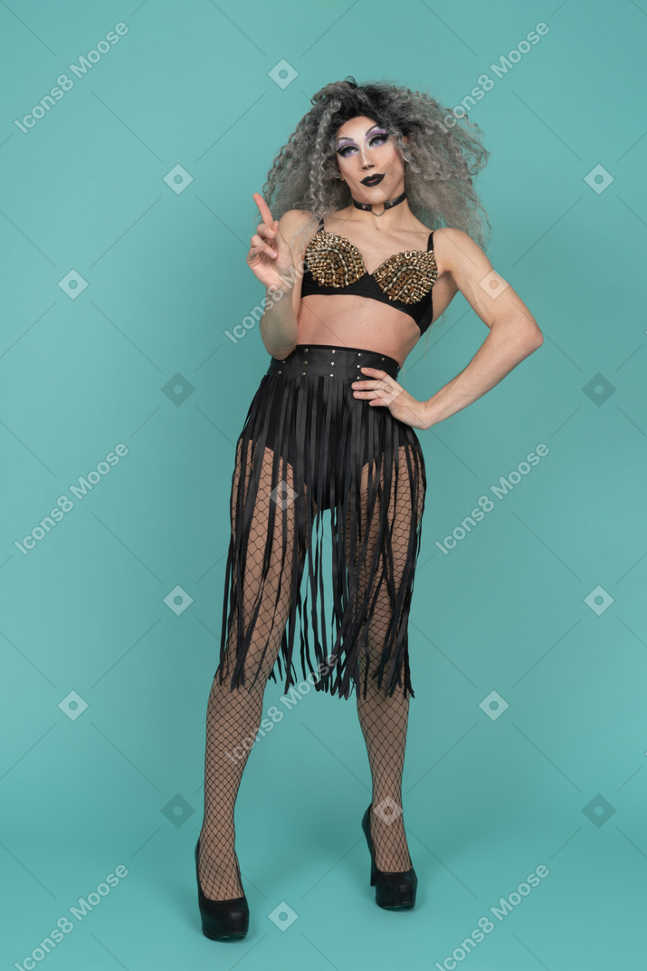 Drag queen in all black outfit shaking finger