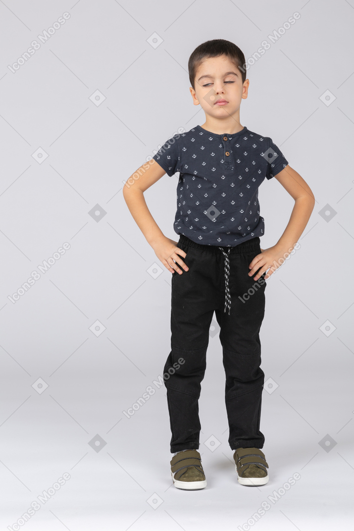 Front view of a boy standing with hands on hips