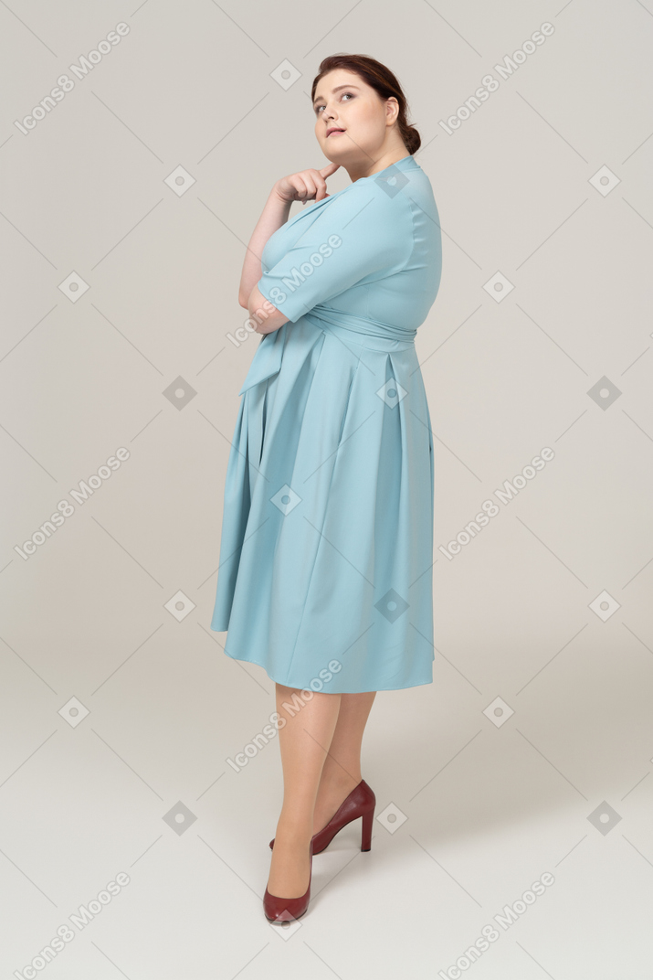 一个穿着蓝色连衣裙做梦的女人的侧视图