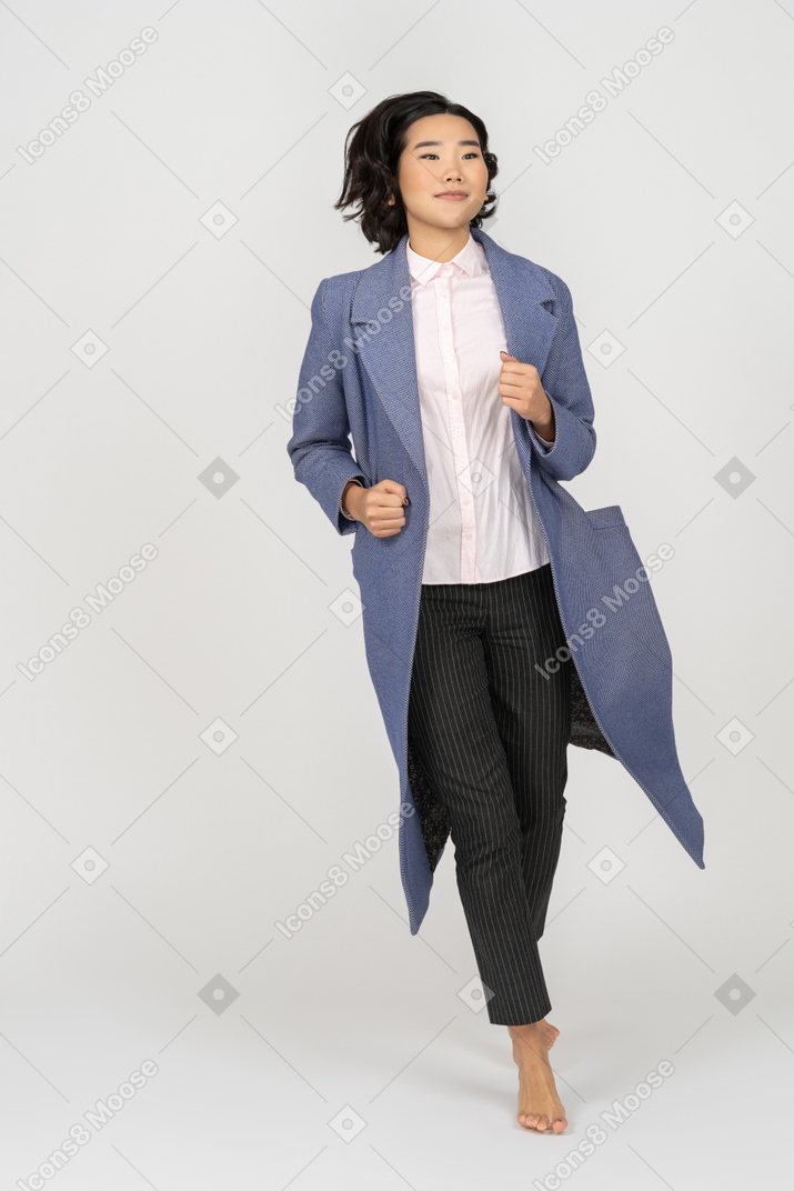 Happy woman in coat running