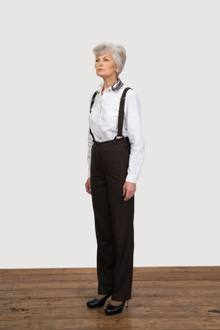 Three-quarter view of a suspicious old woman in office clothing