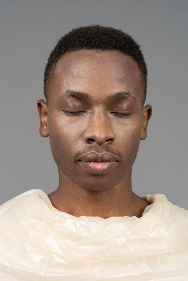 Close-upfront portrait of an african male wrapped in plastic