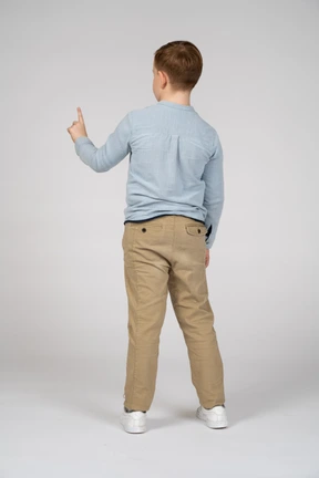 Back view of a boy pointing up with finger