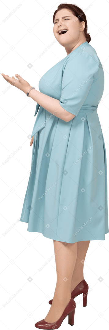 Vista laterale di una donna in abito blu che sbadiglia