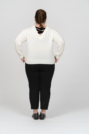 Vista posteriore di una donna grassoccia in maglione bianco in posa