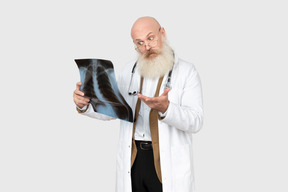 Médico maduro sosteniendo una radiografía