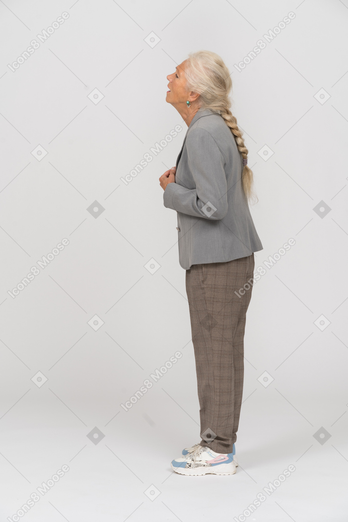 Sad old lady in suit standing in profile