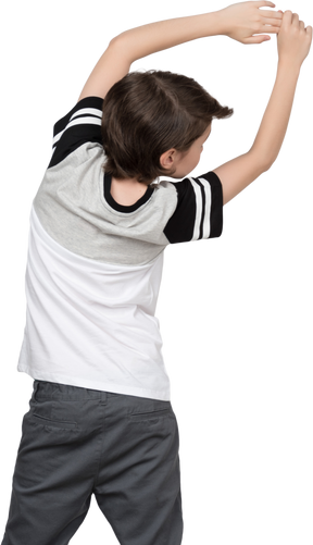 Back view of a boy leaning to the right with raised arms