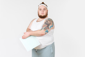 Big guy in sportswear covering digital scales