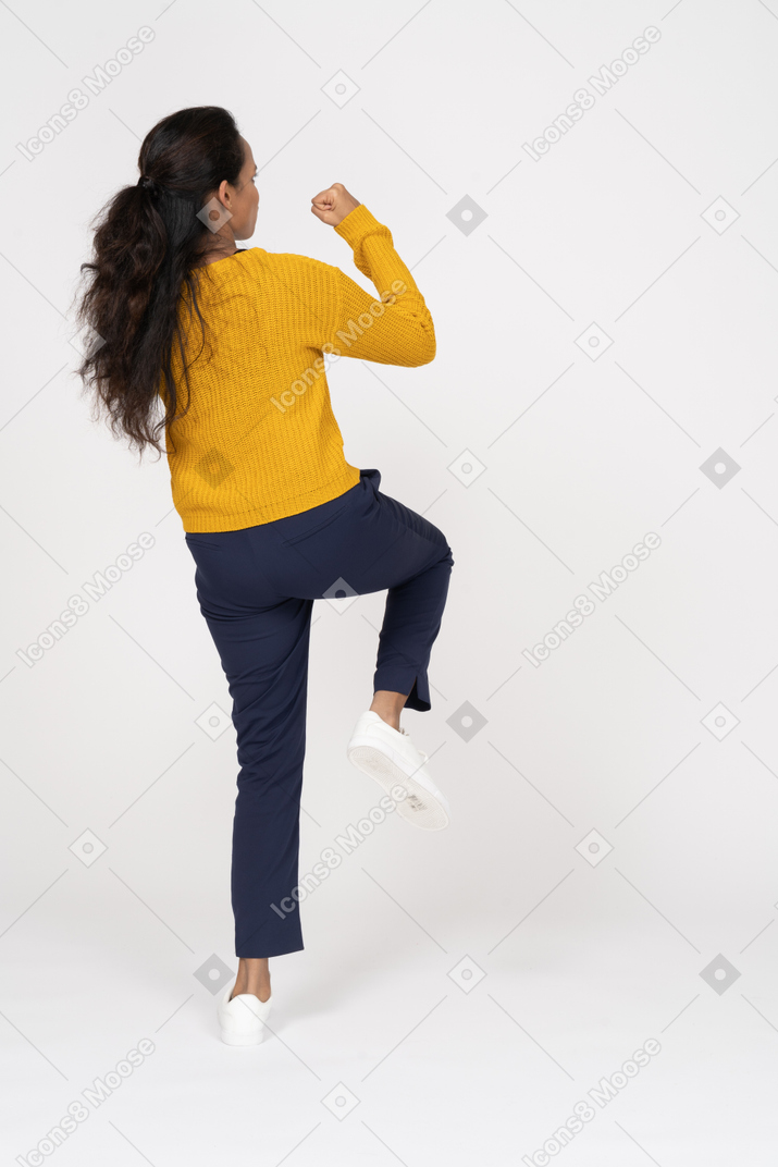 Rear view of a girl in casual clothes exercising