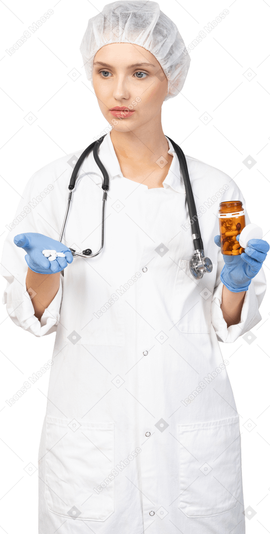 Vue de face d'une jeune femme médecin tenant des pilules
