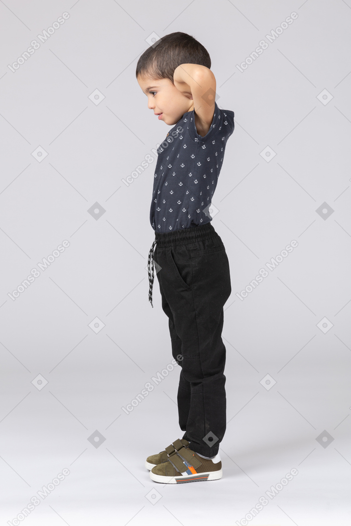 Side view of a cute boy posing with hands behing head