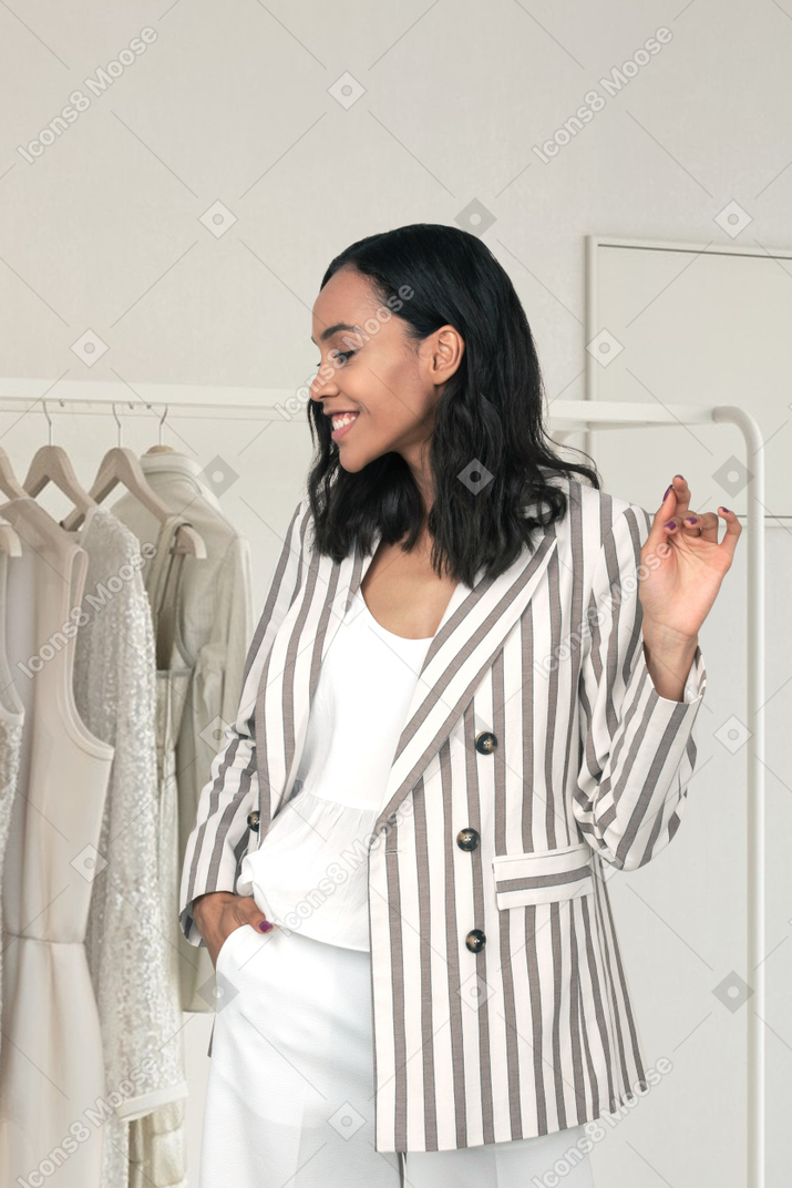 Stylish young woman standing near a clothes rack