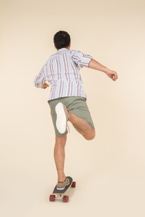 Young caucasian guy standing on skate