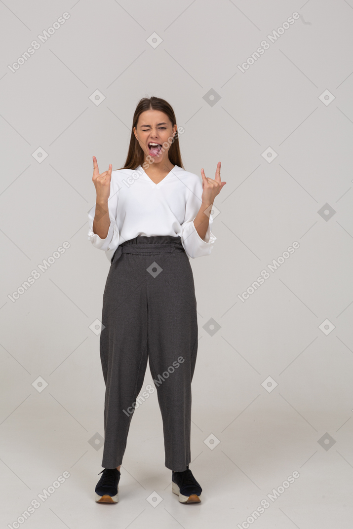 一位身着办公室服装的年轻女士的前视图，展示摇滚手势