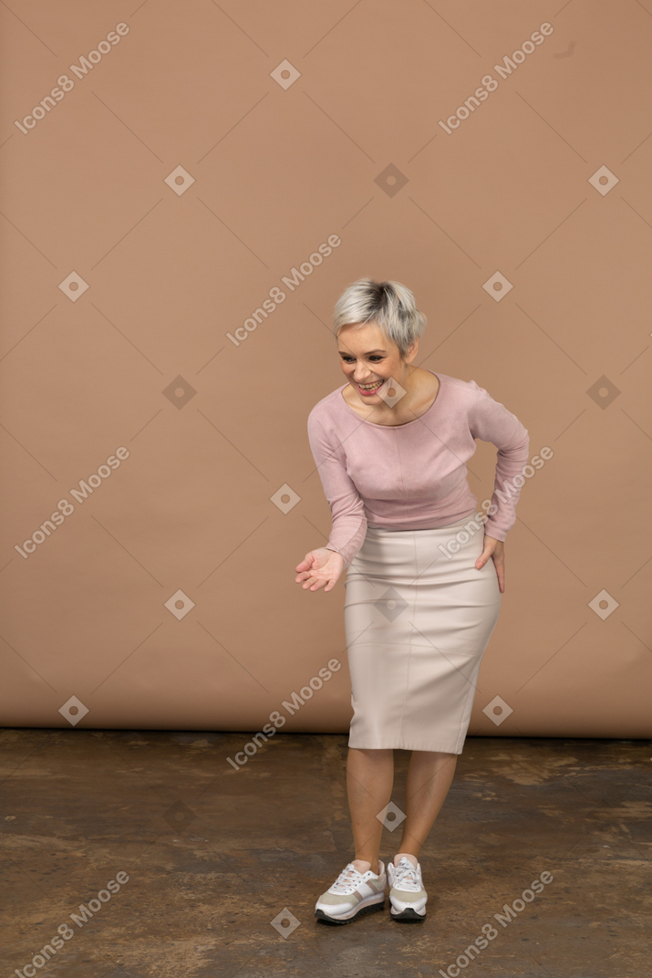 一个穿着休闲服的快乐女人的前视图，做一个欢迎的手势