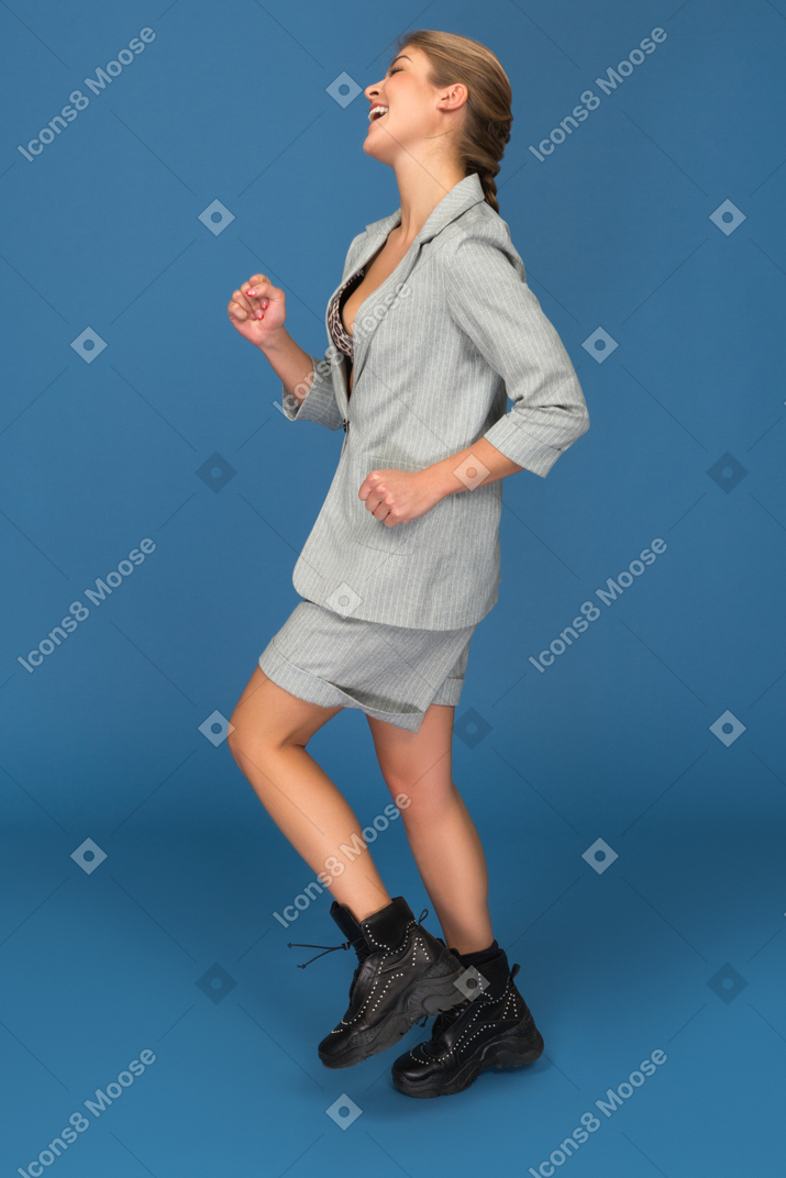 Smiling young woman running sideways