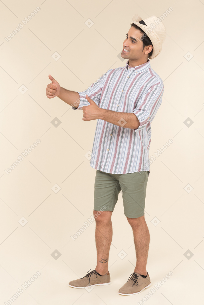 Young guy in good mood showing thumbs up