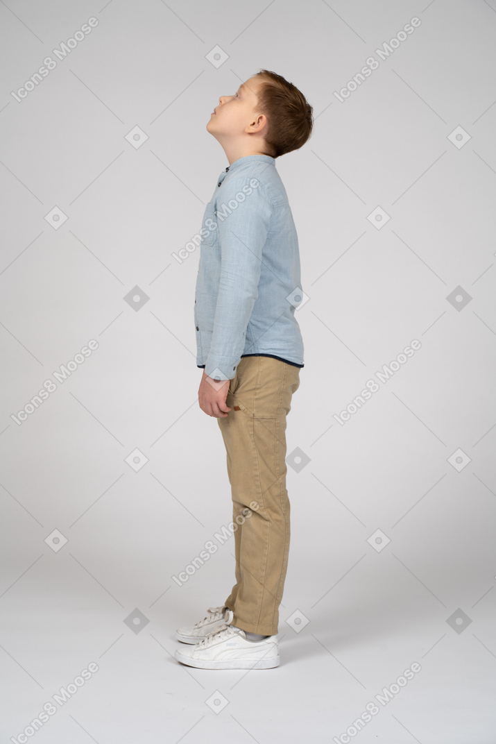 Vista lateral de un chico lindo mirando hacia arriba