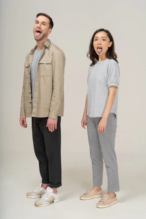 Three-quarter view of young couple showing tongue