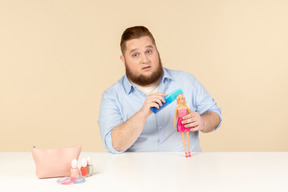 Big man holding hair brush and barbie doll