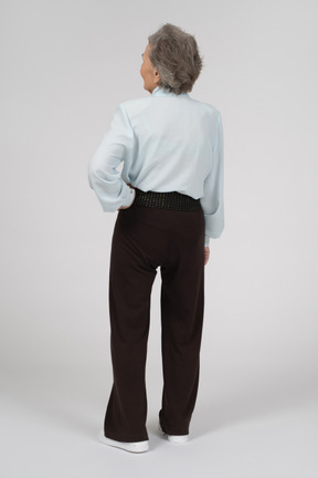 Vista posteriore di una donna anziana con una mano sull'anca