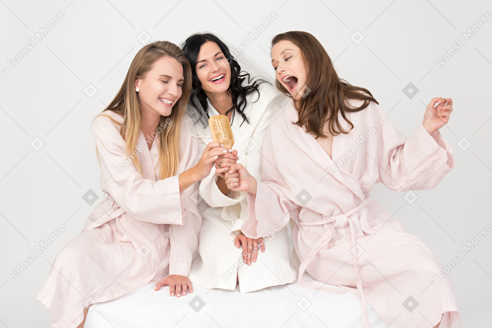 Bride and bridesmaids singing into a brush