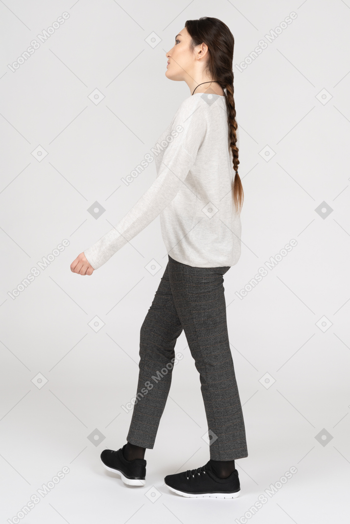 横に歩いているスリムな若いブルネットの女性