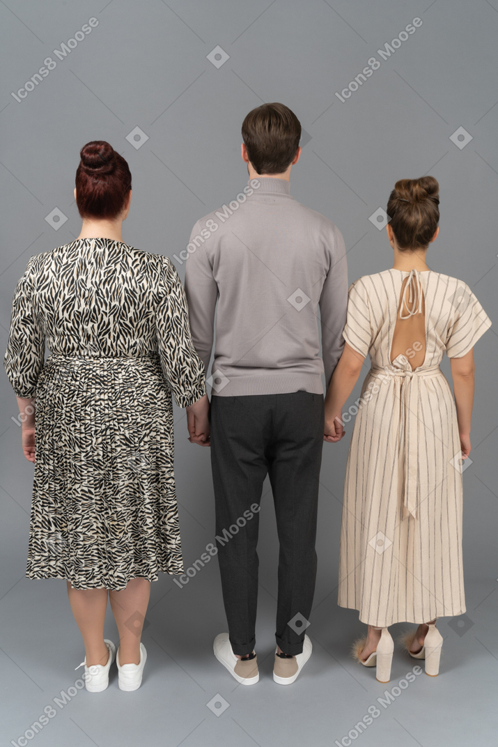 Two women and man holding hands