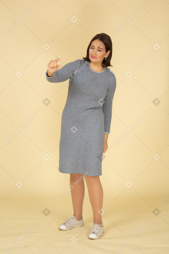 Front view of a woman in grey dress showing a small size of something