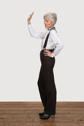 Side view of an old greeting lady in office clothing
