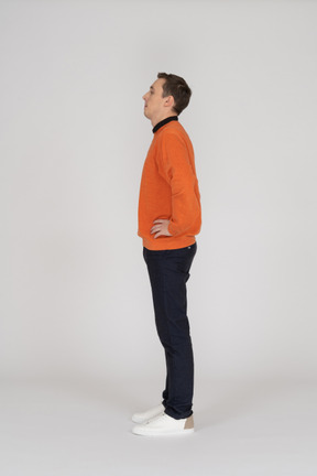 Young man in orange sweatshirt standing