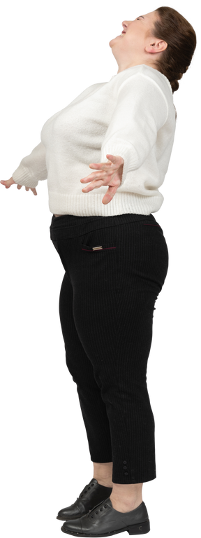 Happy plus size woman in white sweater standing in profile