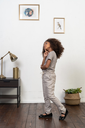 Good looking girl kid posing on the apartment background