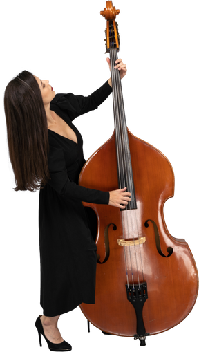 Figura intera di una giovane donna in abito nero che suona il contrabbasso mentre si appoggia allo schienale