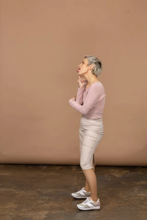 Side view of a woman in casual clothes making faces