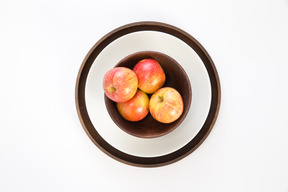 Apples in wooden plate on some plates